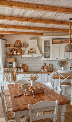 a kitchen with white cabinets and wooden floors is pictured in this image, the table has chairs around it