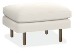 a white footstool with wooden legs and a cushion on the bottom, sitting in front of a white background