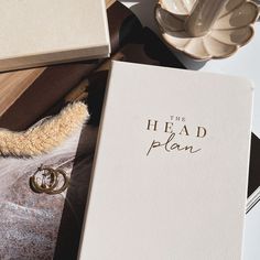 an open book sitting on top of a table next to a pair of wedding rings