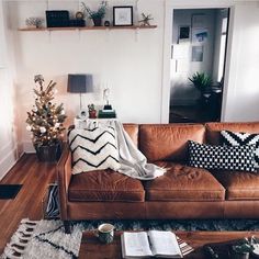 a living room with a couch, coffee table and christmas tree in the corner on the wall