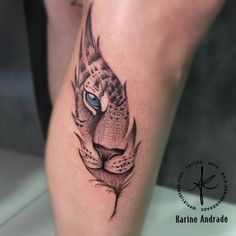 a tattoo on the leg of a person with a tiger's head and blue eyes