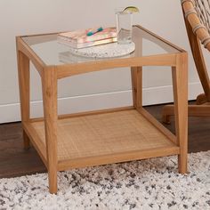 a glass table with a book and drink on it