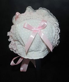 Printed white cotton with pink double sided satin ribbon bows and ties. Bonnet has white lining.. White and pink lace Size / Measurement from under ear lobe around top of head to under other ear lobe preemie/ newborn 10 inches 0-3 months/ 11 inches 3-6 months / 12 inches 6-9 months / 13 inches 9-12 months / 14 inches 12-18 months/ 15 inches 18-24 months / 16 inches Cute White Fitted Bonnet, Cute Fitted White Bonnet, White Cotton Bonnet As A Gift, White Cotton Bonnet As Gift, Cute Pink Cotton Bonnet, Heirloom Bonnet, Lace Baby Bonnet, Newborn Bonnet, Satin Ribbon Bow