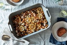 a casserole dish with lemons and chickpeas