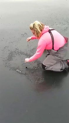 a woman kneeling down on top of a wet ground