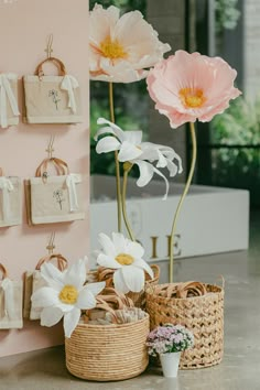 flowers and baskets are on the counter in front of a pink wall with calendars