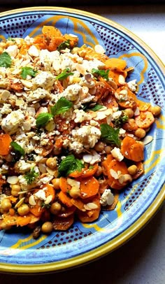 a blue and yellow plate topped with lots of veggies next to a fork