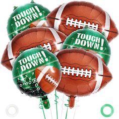 four football balloons with the words tough down printed on them and green balls attached to them