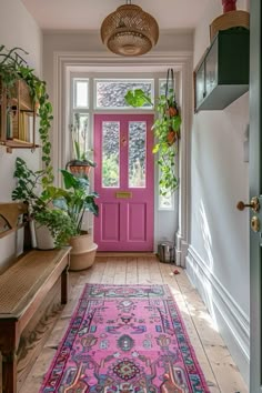 a bright pink door is in the hallway with potted plants and a bench on the side