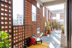 an outdoor area with potted plants and wooden slats on the wall, surrounded by windows