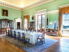 the dining room is set up for a formal dinner with white tablecloths and chairs