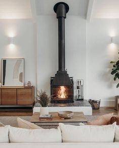 a living room filled with furniture and a fire place in the middle of the room