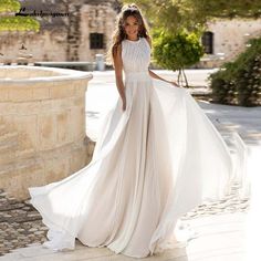 a woman in a white dress is posing for the camera with her hand on her hip