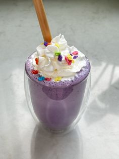 a purple drink with whipped cream and sprinkles