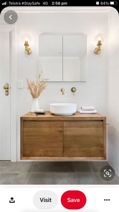 a bathroom with a sink, mirror and lights on the wall above it's counter