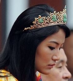 a woman wearing a tiara and looking at her cell phone