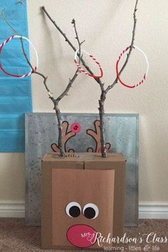 a cardboard box with some branches in it and a reindeer face on the side,