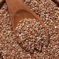 a wooden spoon filled with seeds on top of a table