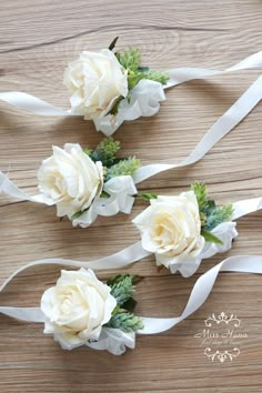 three white flowers are tied together with ribbons