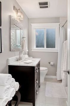 a bathroom with a toilet, sink and mirror in it's center piece is shown