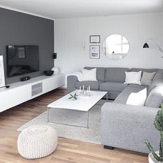 a living room filled with furniture and a flat screen tv sitting on top of a wooden floor