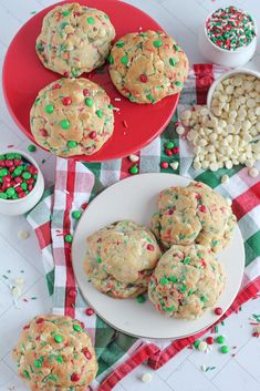 cookies on a plate with sprinkles next to bowls of candy caned