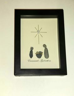 a black frame with a nativity scene in the middle and an image of two people under a star