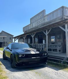 a black sports car parked in front of a building with a sign that says restaurant the maverrick