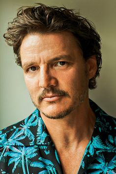 a man with a moustache wearing a hawaiian shirt