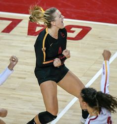 a female volleyball player is celebrating her team's victory