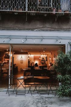 a person sitting at a table in front of a building