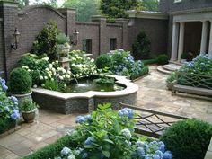 a garden with blue and white flowers in the center, surrounded by greenery on both sides