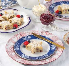 a table topped with blue and white plates filled with desserts on top of it