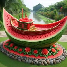 a boat made out of watermelon sitting on top of rocks