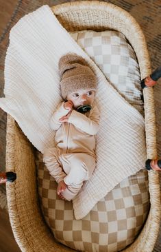 a baby is laying in a basket on the floor