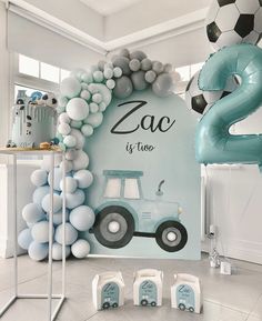 a room decorated with balloons and decorations for a baby's first birthday, including a tractor