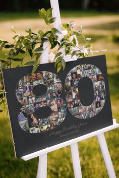 a white easel holding a sign with photos and greenery in the shape of an 80