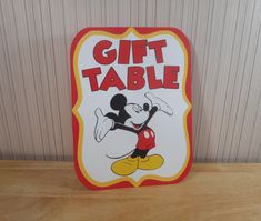 a sign that says gift table with mickey mouse on it's face and the words,