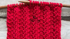 a red knitted cloth hanging on a wooden hanger