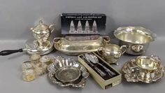 an assortment of silver items including cups, saucers and spoons