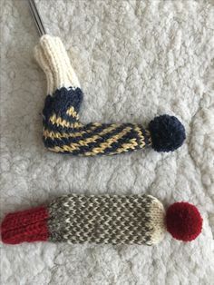 two knitted items are laying on the floor