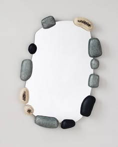 a mirror that has some rocks on it and is hanging from the side of it