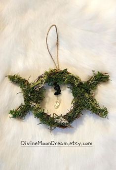 an ornament made out of moss on a white furnishce with a black bead