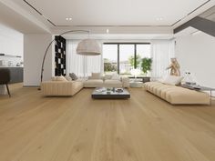 a modern living room with wood flooring and white walls, large windows on the side