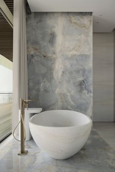 a large white bath tub sitting next to a window