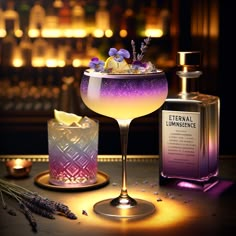 a purple drink with lavender and lemon garnish in a glass next to a bottle