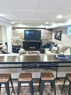 a living room filled with furniture and a flat screen tv mounted on the wall above a fireplace