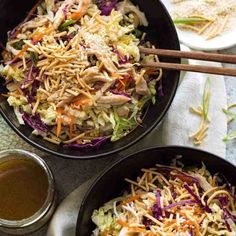 two black pans filled with coleslaw slaw and some chopsticks