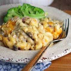 a white plate topped with macaroni and cheese next to a broccoli