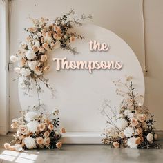 flowers are arranged in front of a sign that says, the thompsons